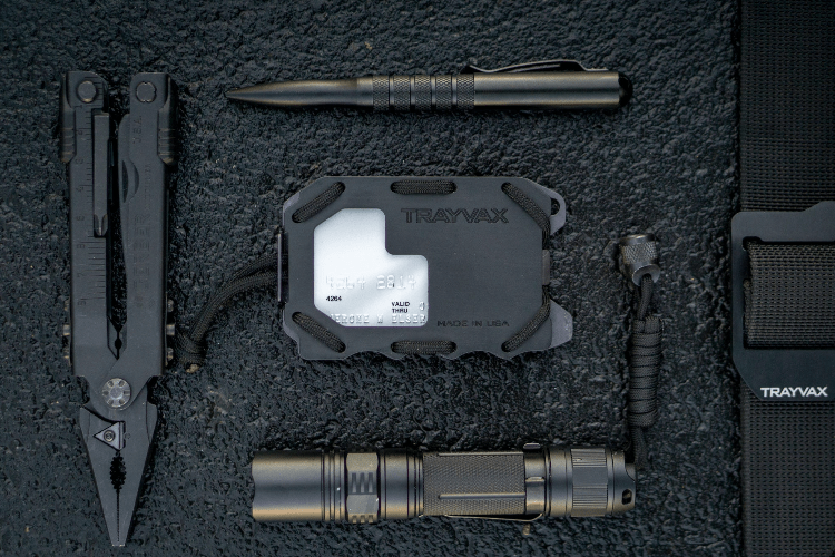 Black Original 2.0 Wallet Laying On Textured Rock with Black Multi-tool, Flashlight, Metal Pen, and Trayvax Black Designer Belt